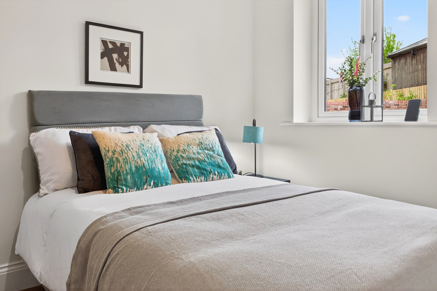 Bedroom three with garden-facing window and contemporary furnishings.