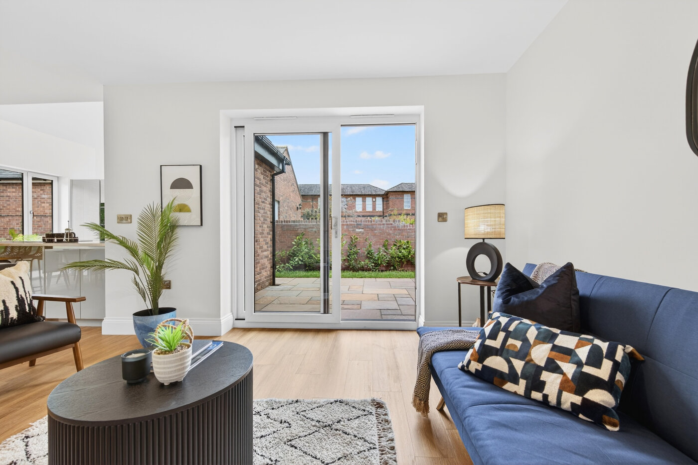 Living room with sofa, Amtico flooring and sliding doors to the patio garden.