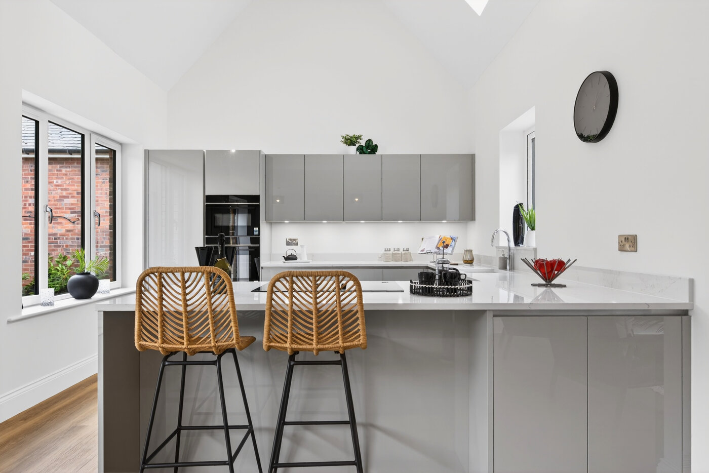 Kitchen island with rattan bar stools, Silestone Quartz worktop and vaulted ceiling.