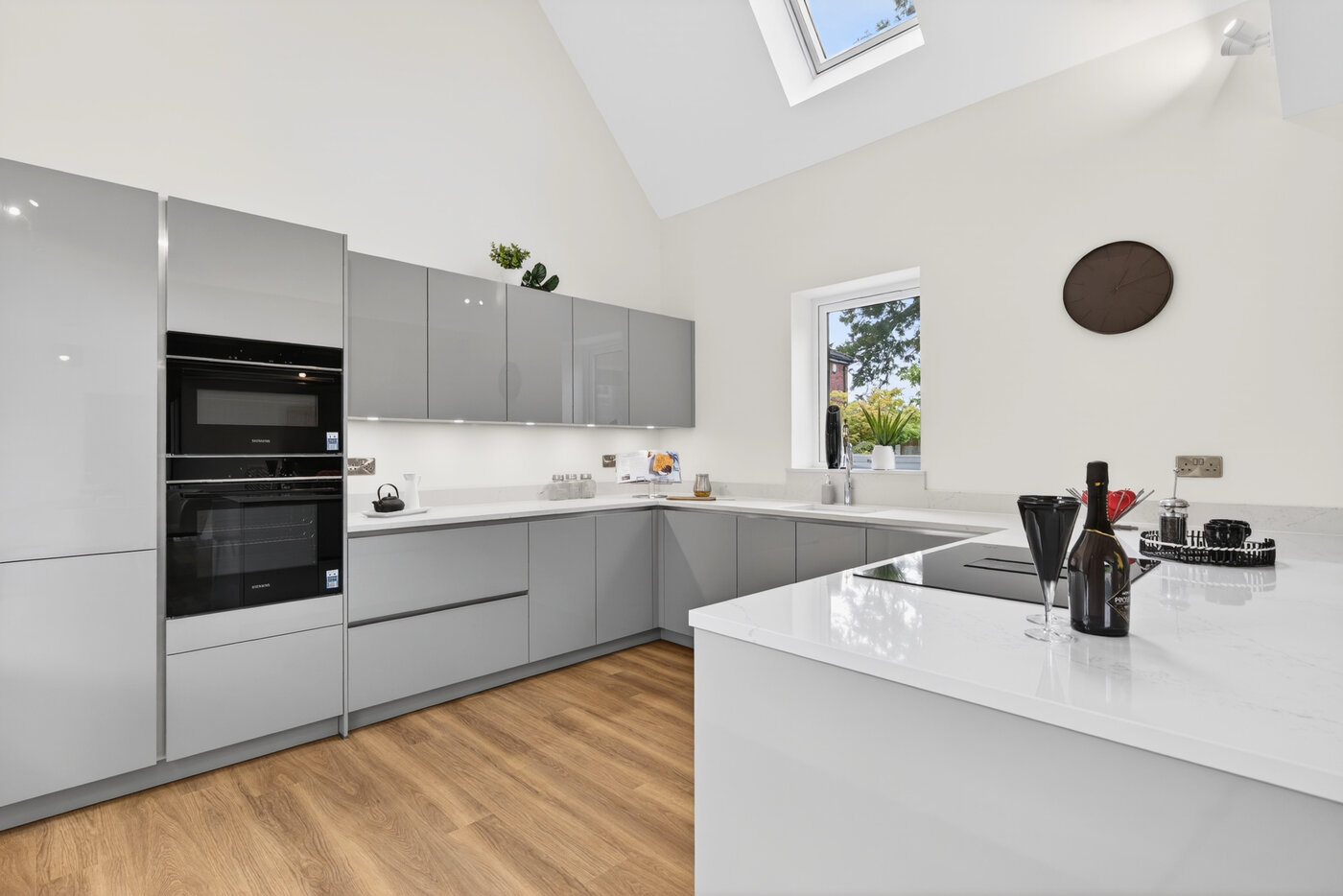 Full kitchen view showing L-shape layout, Siemens tower, and Velux skylight flooding the space with light.