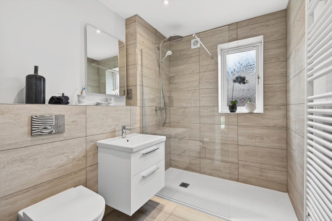 Walk-in shower with Duravit fittings, chrome fixtures and stone-effect tiling.