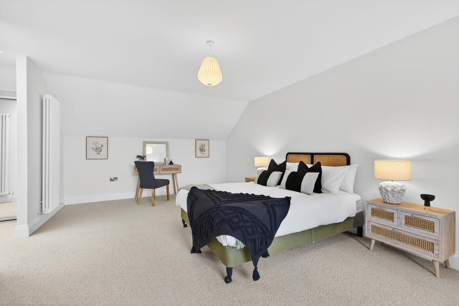 Master bedroom suite at Orchard Place with oak door, considered styling and Cobb wool carpet — vaulted ceiling and en-suite, Cockermouth bungalow.
