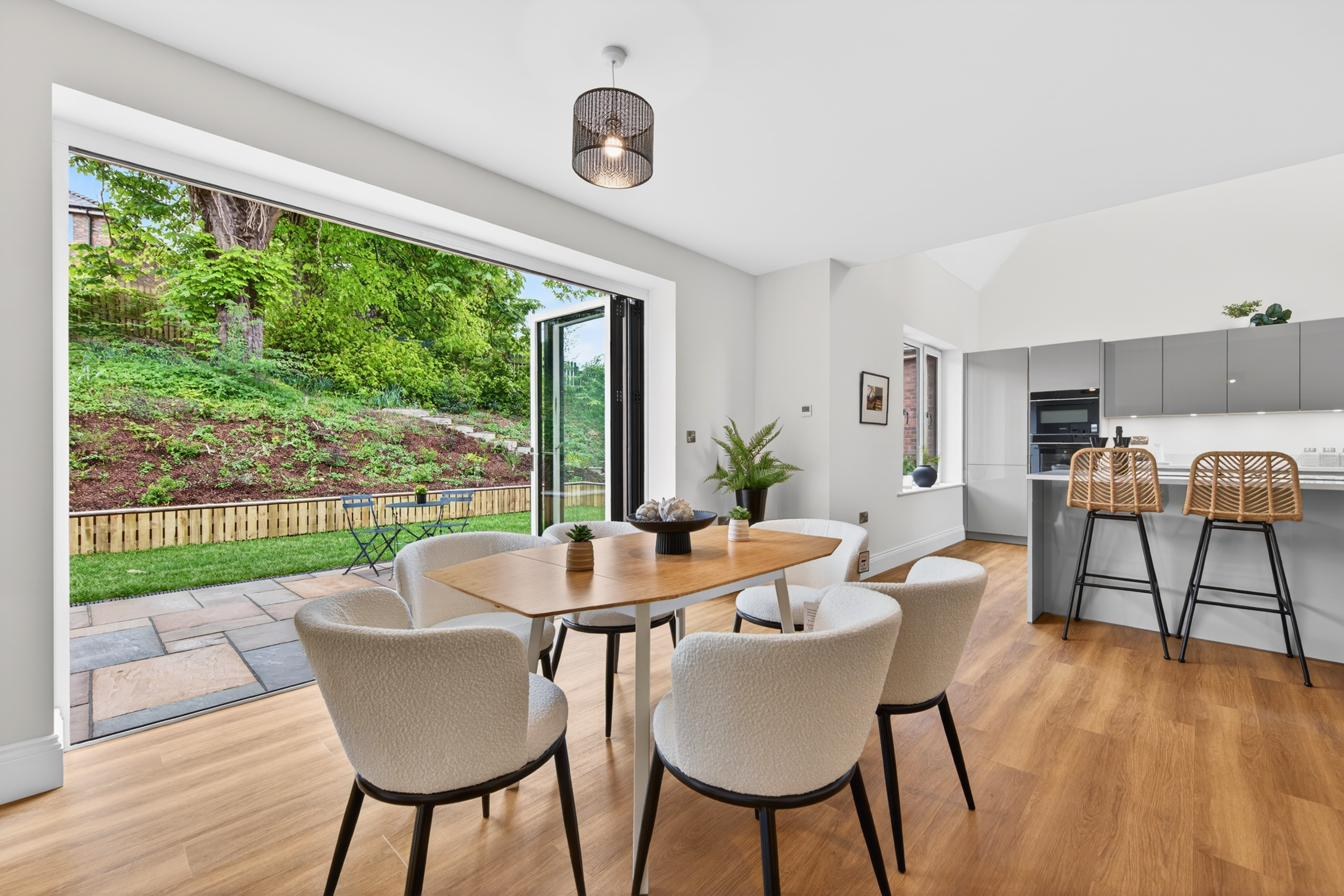Open-plan kitchen, dining and living with bi-fold doors opening to the garden patio.